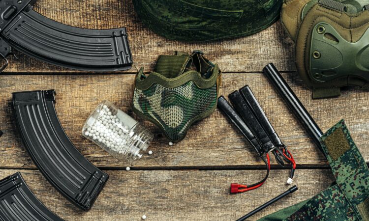 Close up of airsoft gun magazine and airsoft balls on wooden background