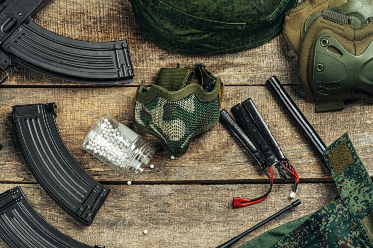 Close up of airsoft gun magazine and airsoft balls on wooden background